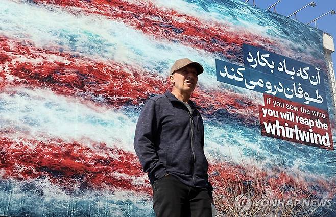 반미 메시지 선전 문구 앞에 서있는 이란 시민 [EPA=연합뉴스. 재판매 및 DB금지]