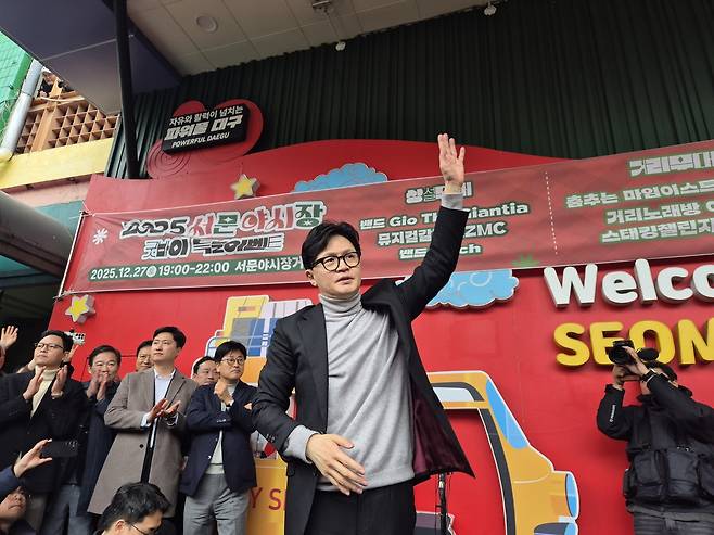 국민의힘 한동훈 전 대표가 27일 대구 서문시장을 방문해 상인 및 시민들과 대화하고 둘러본 후 연단에 오르며 인사하고 있다.