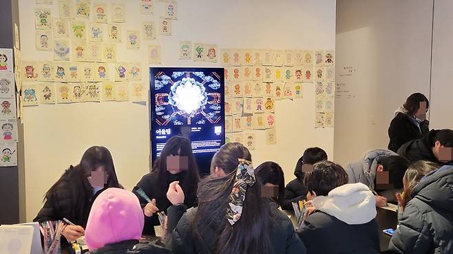 많은 관람객이 참여형 전시를 위해 자신만의 그림을 그리고 있다.