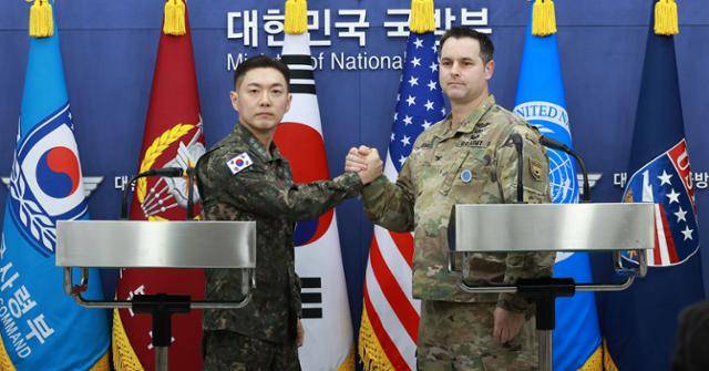 장도영(왼쪽) 합동참모본부 공보실장과 라이언 도날드 주한미군사 공보실장이 25일 서울 용산구 국방부에서 2026 자유의방패(FS) 연습 계획을 발표한 후 손을 맞잡고 있다. 연합뉴스