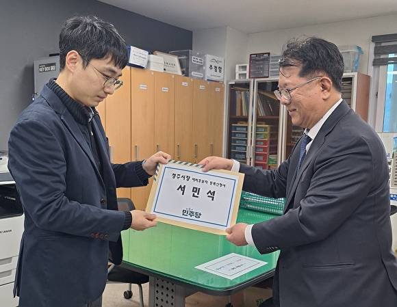 서민석(오른쪽) 변호사가 27일 청주시장 예비후보 등록 서류를 청주상당구선거관리위원회 관계자에게 전달하고 있다. [사진=서민석 청주시장 예비후보]