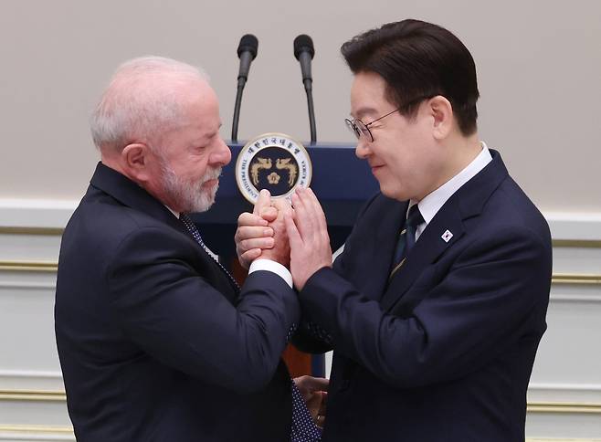 이재명 대통령이 23일 청와대에서 열린 만찬에서 루이스 이나시우 룰라 다시우바 브라질 대통령과 손을 맞잡고 있다. 룰라 대통령은 브라질의 희토류 및 니켈 등 핵심광물 매장량을 언급하며 “핵심광물에 대해 한국 기업의 투자를 유치하기 원한다”고 했다.  [연합]