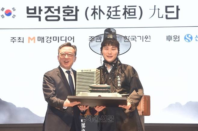 박정환(오른쪽) 9단이 27일 서울 중구 신한은행 본점 특설 대국장에서 열린 제1회 신한은행 세계 기선전 결승 3번기 최종국에서 중국의 왕싱하오 9단을 꺾고 우승한 뒤 열린 시상식에서 정상혁 신한은행장과 기념사진을 찍고 있다. 2026.2.27 한국기원 제공