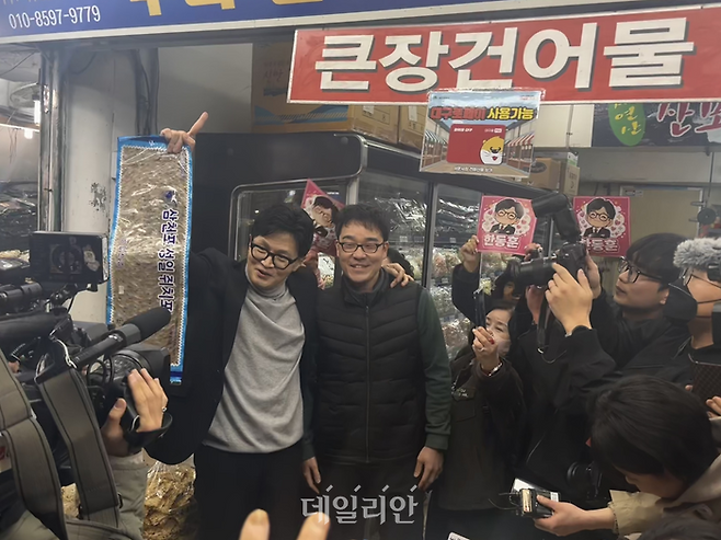 한동훈 국민의힘 전 대표가 27일 오후 대구 중구 서문시장에 위치한 후니건어물 상가 상인과 어깨동무를 하며 사진 촬영을 하고 있다. ⓒ데일리안 오수진 기자