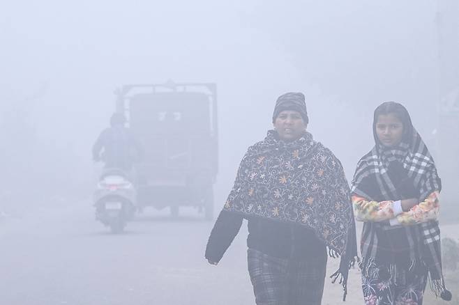 인도 여성들이 스모그 속에서 걷고 있다 [사진 출처 = AFP 연합뉴스]
