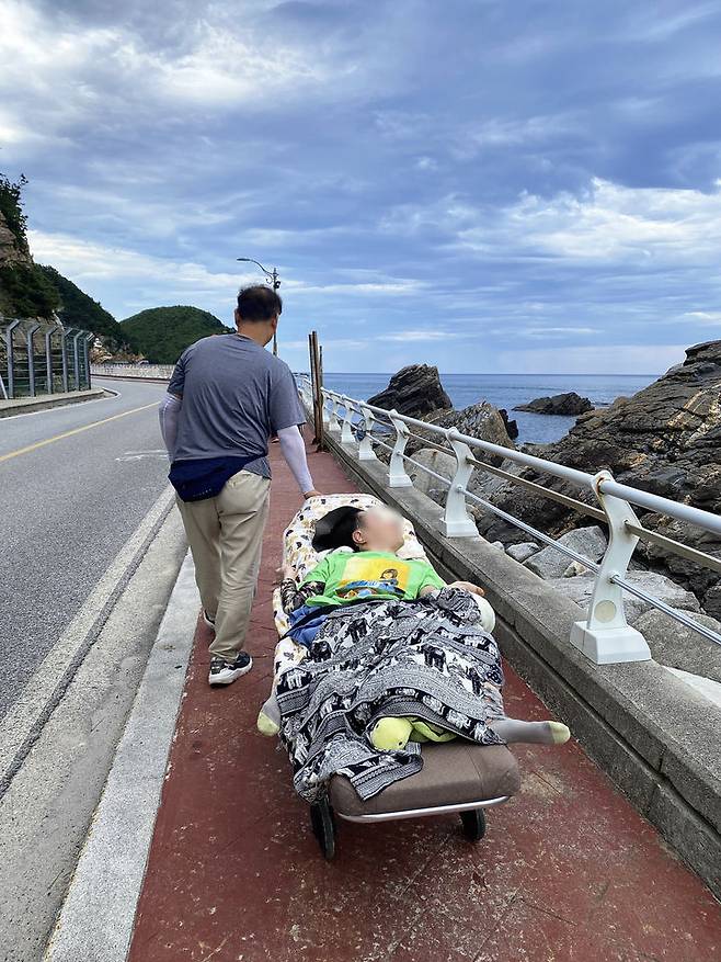 [서울=뉴시스] 이상욱 잔디네집 시설장이 2024년 와상장애인과 정동진 6번 국도 여행을 하는 모습 (사진=이상욱씨 제공) 2026.02.27. photo@newsis.com *재판매 및 DB 금지