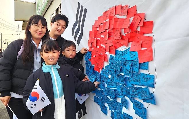 ▲ 별산런에 참가한 가족이 태극기 모양 게시판에 독립운동을 기리는 메시지를 남기고 있다.