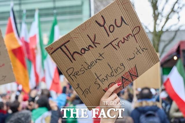 지난달 28일(현지시간) 독일 베를린 주재 미국 대사관 앞에서 미국과 이스라엘의 이란 공습에 지지하는 시위에 참여한 한 여성이 도널드 트럼프 미국 대통령에게 감사하는 손팻말을 들고 있다. /베를린=AP.뉴시스