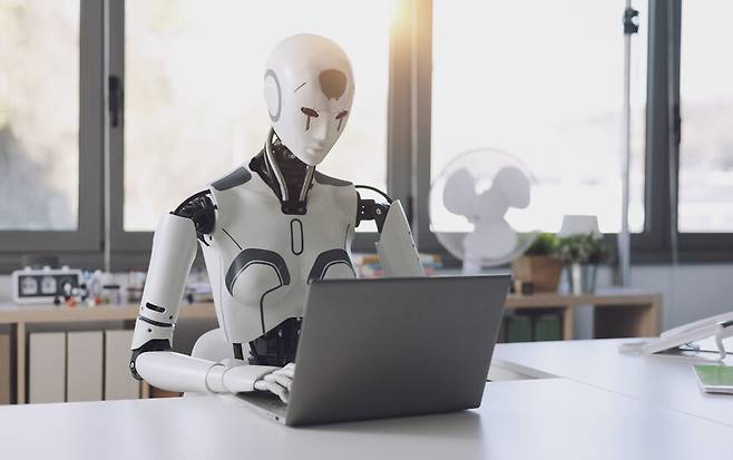 인간을 닮은 휴머노이드로봇이 노트북컴퓨터로 작업하는 모습. 게티이미지뱅크