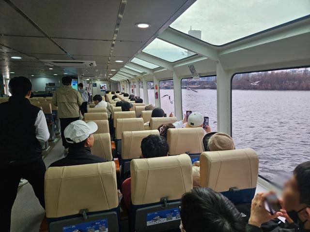 1일 한강버스에 탄 이들이 창가에 앉아 경치를 바라보거나 사진을 찍고 있다. 오세운 기자