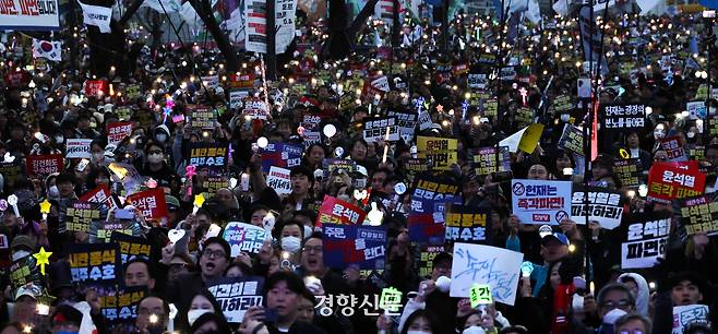 지난해 3월 15일 서울 광화문 동십자각 앞에서 시민들이 윤석열 전 대통령 탄핵을 촉구하며 응원봉을 들고 구호를 외치고 있다. 성동훈 기자