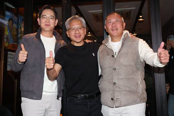 Nvidia CEO Jensen Huang, center, takes a photo with Samsung Electronics Executive Chairman Lee Jae-yong, left, and Hyundai Motor Group Executive Chair Euisun Chung during a dinner in a chicken restaurant in southern Seoul on Oct. 30, 2025. [JOINT PRESS CORPS]