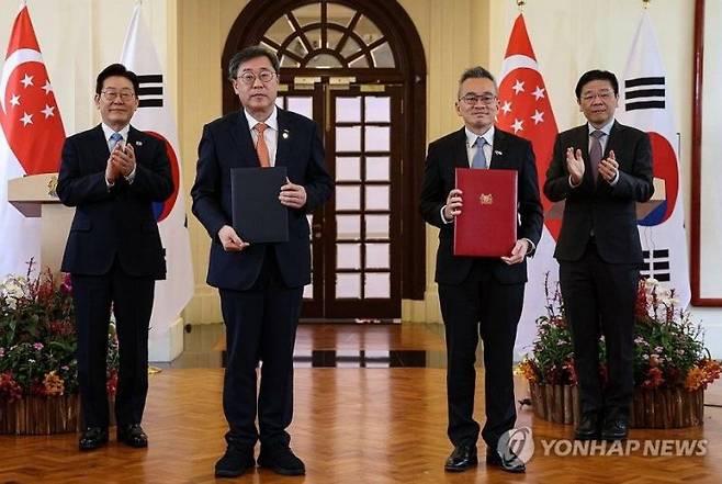 박윤규 정보통신산업진흥원장과 찬 찬 싱가포르 홈팀과학기술청 청장이 2일 싱가포르 외교부 청사에서 이재명 대통령과 로런스 웡 싱가포르 총리가 참석한 가운데 공공안전분야 AI 및 디지털 기술 협력에 관한 MOU를 체결한 뒤 기념촬영을 하고 있다. 연합뉴스