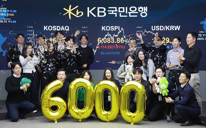 코스피가 종가 기준 사상 처음 6000선을 돌파한 25일 오후 서울 영등포구 KB국민은행 딜링룸에서 직원들이 축하 세리머니를 하고 있다. /뉴스1