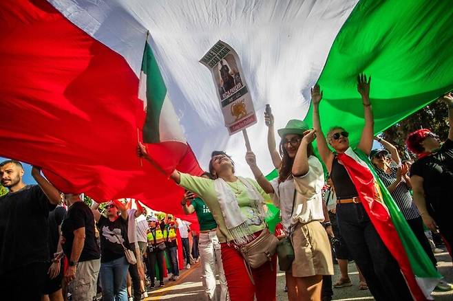 1일(현지시각) 미국 캘리포니아주 로스앤젤레스 연방정부 청사 앞에서 이란계 주민들이 1979년 이슬람 혁명 이전의 이란 국기를 흔들며 미국과 이스라엘의 이란 공격을 축하하고 있다. AFP 연합뉴스