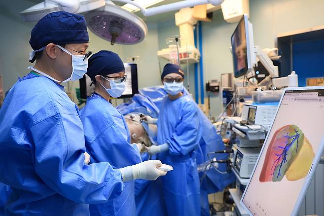유진수 삼성서울병원 이식외과 교수(왼쪽)가 인공지능(AI) 기반 3차원(3D) 수술 계획 플랫폼 리버라이즈를 활용해 간이식 환자의 수술 과정을 의료진과 상의하고 있다.  삼성서울병원