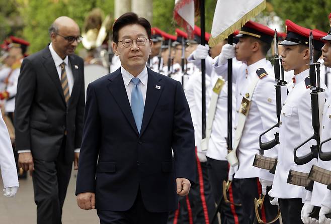 이재명 대통령이 2일 싱가포르 외교부 청사에서 열린 국빈방문 환영식에서 타르만 샨무가라트남 대통령과 의장대를 사열하고 있다. [연합]