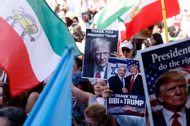 [로스앤젤레스=AP/뉴시스] 1일(현지 시간) 미 캘리포니아주 로스앤젤레스에서 미국과 이스라엘의 이란 공습을 지지하는 시위대가 이란 국기와 손팻말을 들고 행진하고 있다. 미국 전역에서 이란 공습을 지지하거나 반대하는 시위가 열렸다. 2026.03.02.