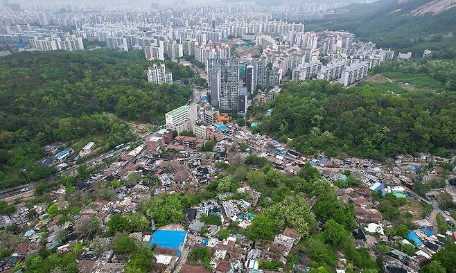 이재명정부가 집값 안정을 위해 주택 공급 확대 대책도 내놓고 있지만 공급 시장의 중요한 축인 민간 정비사업은 각종 규제와 공사비 상승으로 지지부진한 상황이다. 사진은 재개발을 위해 지난해 철거에 들어간 서울 노원구 중계본동 백사마을과 주변 아파트 단지 모습. 연합뉴스