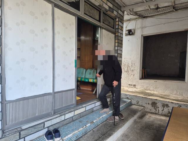 이승훈(70·가명) 씨가 불편한 다리 때문에 지팡이를 짚은 채 집을 나서고 있다. 김지수 기자