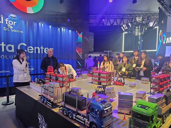 3일(현지시간) MWC26 SK텔레콤 전시관에서 관람객들이 풀스택 AI 개념을 쉽게 이해할 수 있는 '지게차 이벤트'에 참여하고 있다.