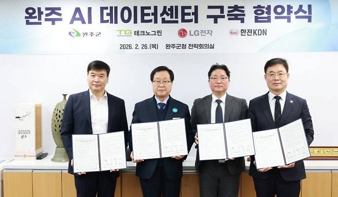 지난달 26일 최진수 한전KDN 신사업개발본부장이(왼쪽) 완주 AI 데이터센터 구축 업무 협약식에 참여한 기관 참석자들과 협약 직후 기념사진을 촬영하고 있다. 한전KDN.