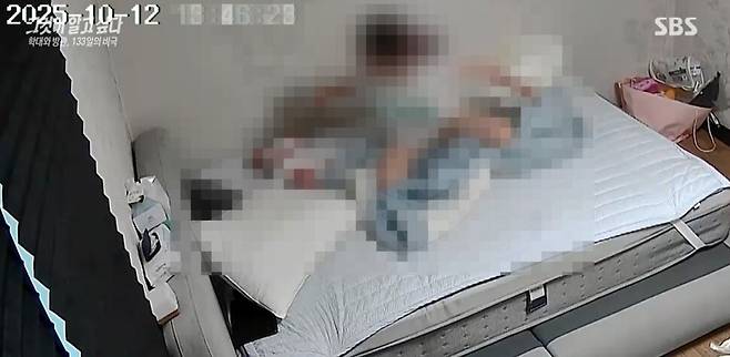 아기를 때리려는 시늉을 하며 주먹으로 위협하는 친모 ㄱ씨의 모습. 에스비에스(SBS) ‘그것이 알고싶다’ 방송 화면 갈무리