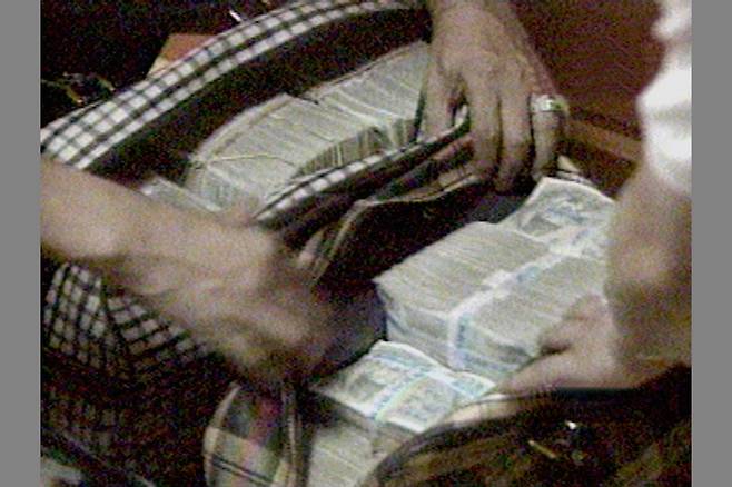 Bundles of cash are seen in two golf bags belonged to Shin Chang-won in an undated photo. The bags were found at his hideout in South Jeolla after his arrest in 1999. [JOONGANG ILBO]