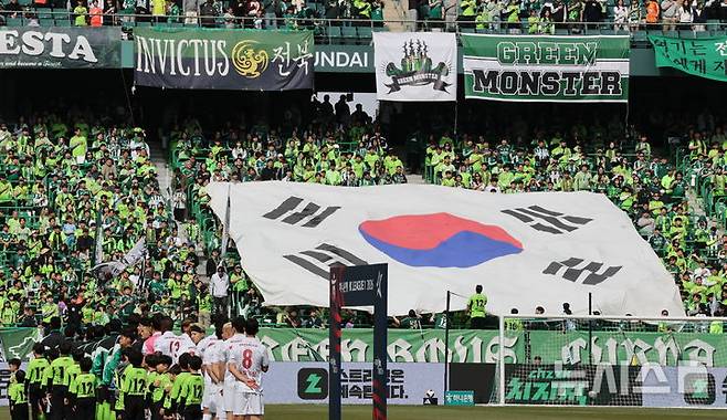 [전주=뉴시스] 김얼 기자 = 제107주년 3·1절을 맞이한 1일 전북 전주시 전주월드컵경기장에서 열린 하나은행 K리그1 2026 1라운드 전북 현대와 부천 FC의 경기에 앞서 전북현대 팬들이 대형 태극기를 들어올리고 있다. 2026.03.01. pmkeul@newsis.com