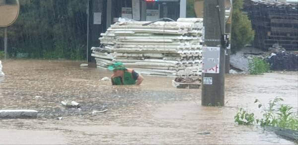남양주시자율방재단이 작년 폭우로 잠긴 진접읍 도로에서 권 단장이 맨홀뚜껑 쓰레기를 치우고 있다.