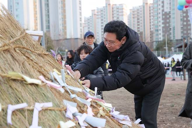 이상일 시장이 소망을 담은 쪽지를 달집 태우기에 달고 있다. ⓒ용인시 제공
