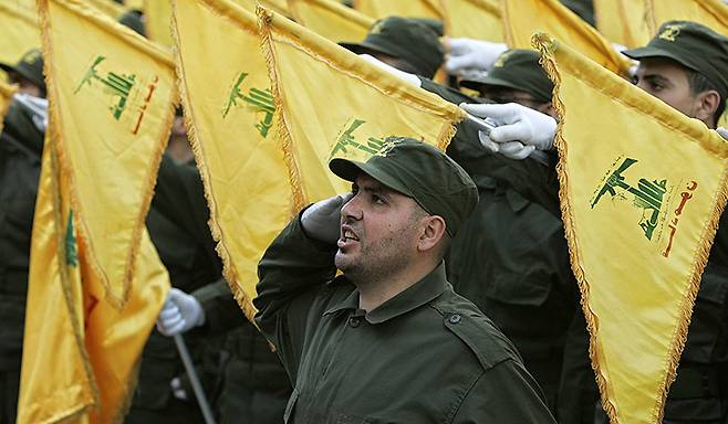 레바논 수도 베이루트에서 친이란 무장단체 헤즈볼라의 대원들이 노란색 헤즈볼라기를 들고 행진하고 있다. 베이루트=AP 뉴시스