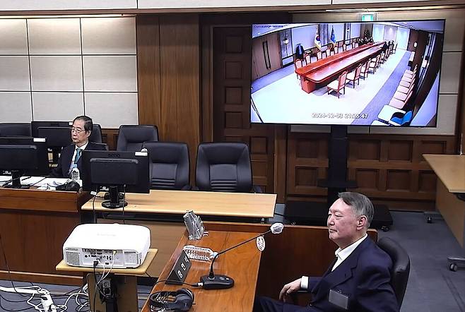 윤석열 전 대통령이 지난해 11월19일 서울 서초구 서울중앙지방법원에서 열린 한덕수 전 국무총리의 내란 재판에 증인으로 출석해 증거 폐회로텔레비전(CCTV) 영상을 지켜보고 있다. 서울중앙지법 제공