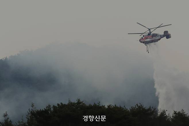 지난 24일 경남 밀양시에서 전날 발생한 산불을 헬기가 진화하고 있다. 정효진 기자