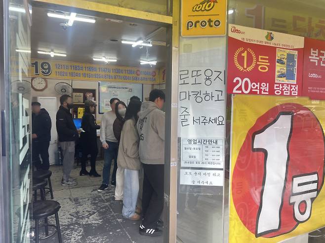 로또 복권 모바일 판매가 시작된 가운데 5일 광주 서구의 한 복권 판매점에서 시민들이 번호를 적은 용지를 들고 차례를 기다리고 있다. /박건우 기자