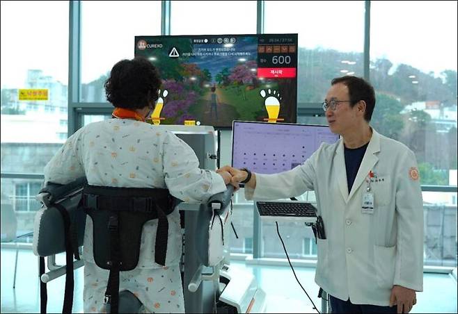보행이 아직 완전하지 않은 재활 환자가 모니터를 보며 게임을 하듯 재활보행기기 위를 걷고 있다. 사진=부산 봉생힐링병원