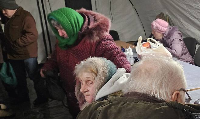 지난달 7일 러시아군 폭격으로 전기·난방이 끊긴 우크라이나 키이우의 아파트단지 내 구호텐트에서 노인들이 몸을 녹이고 있다. 천호성 기자