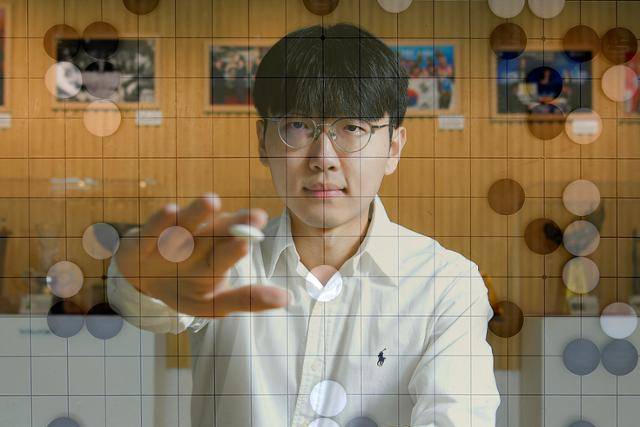 '바둑 세계 랭킹 1위' 신진서 9단이 지난달 27일 서울 성동구 한국기원에서 바둑돌을 들고 있다. 사진은 바둑판과 합성. 신 9단은 한국일보 인터뷰에서 "결코 뛰어넘을 수 없는 존재(인공지능)가 있어 계속 연마할 수 있는 것 같다"고 말했다. 임지훈 인턴기자