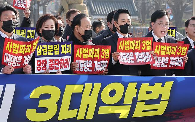 장동혁 국민의힘 대표와 송언석 원내대표를 비롯한 의원들이 5일 서울 종로구 청와대 사랑채 앞 분수대에서 열린 현장 의원총회에서 손피켓을 들고 구호를 외치고 있다. 뉴스1