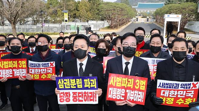 장동혁 대표와 송언석 원내대표를 비롯한 국민의힘 의원들이 5일 청와대 분수대 앞에서 의원총회를 마친 뒤 손팻말을 들고 청와대 방향으로 이동하고 있다. [연합뉴스]