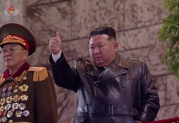 김정은 국무위원장이 지난 25일 밤 평양 김일성광장에서 열린 노동당 제9차대회 기념 열병식 주석단에서 열병종대 행진을 지켜보며 엄지손가락을 치켜들고 있다. 연합뉴스
