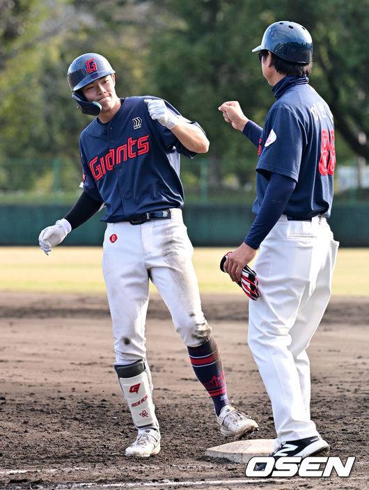 9회초 롯데 김한홀이 안타를 날리고 이헌곤 코치와 주먹을 맞대고 있다.