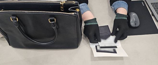 구구스 용산파크타워점 직원이 고객이 예약한 프라다 제품의 보증서를 보여주고 있다. 박윤희 기자