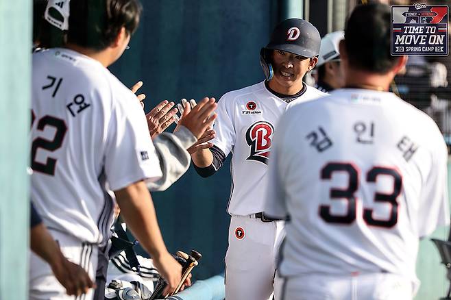 두산 김민석이 3일 일본 미야자키 히사미네 구장에서 열린 미야자키 선샤인과의 연습 경기에서 득점한 뒤 선수단과 하이파이브를 하고 있다. 두산베어스 제공