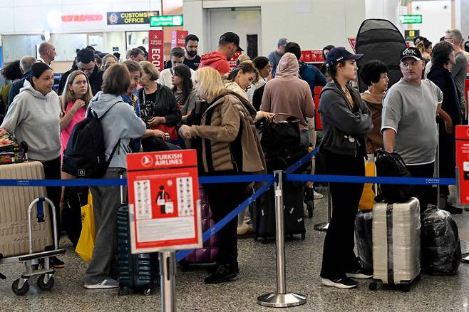 이스라엘과 미국의 이란 공습으로 항공편 운항이 차질을 빚은 가운데, 승객들이 지난 2일(현지시간) 인도네시아 발리의 응우라라이 국제공항에서 기다리고 있다. (사진=AFP)