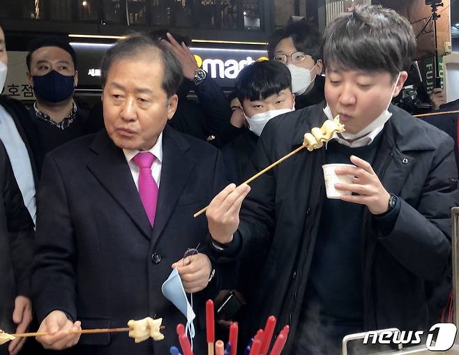 2022년 2월 12일 당시 홍준표 국민의힘 의원과 이준석 당 대표가 대구 동성로 어묵가게에서 어묵을 먹고 있는 모습. 2022.2.12 ⓒ 뉴스1 남승렬 기자