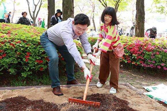 이상일 시장이 어린이와 함께 시민참여정원 행사에서 흙을 고르고 있다. [사진=용인특례시]