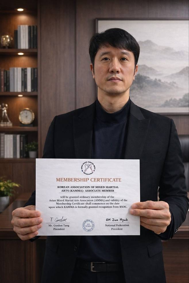 AMMA 준회원 인증서를 들어 보이는 전용재 대한MMA연맹 사무처장