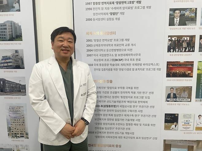 유화승 대전대 대전한방병원 교수가 병원 복도 벽면에 설치된 연혁을 가리키며 동서암센터의 지나온 길을 설명하고 있다. 권복기 건강한겨레 기획위원