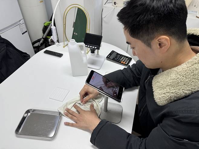 다이아몬드를 닦는 모습을 영상으로 담고 있는 강씨. 백재연 기자